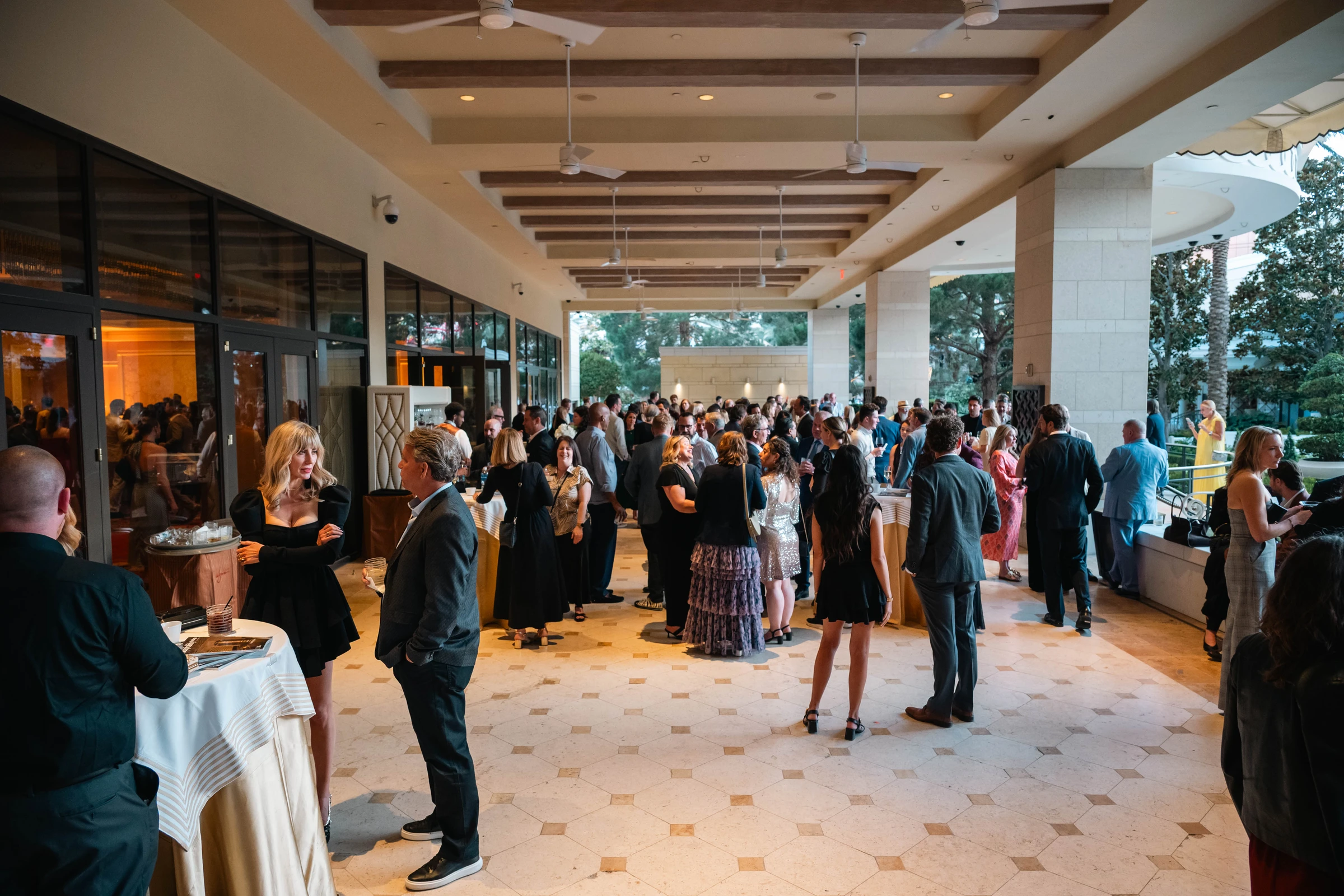 Guests talking and enjoying a cocktail reception on a covered terrace